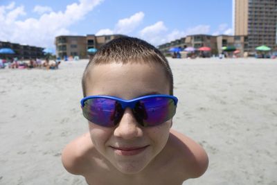 Portrait of boy wearing sunglasses on beach