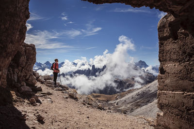 Woman standing on mountain against sky