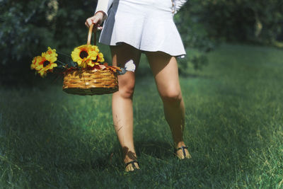 Low section of woman standing on field at park