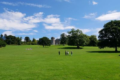 People playing soccer on field against sky