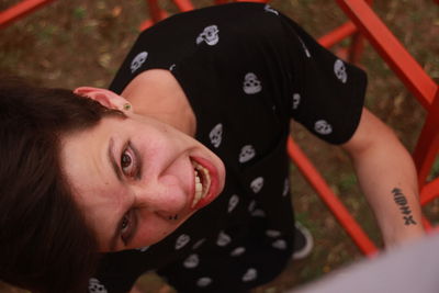 High angle portrait of teenage boy screaming while standing amidst jungle gym