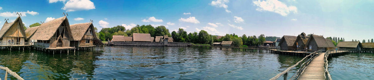 Panoramic view of buildings by river against sky