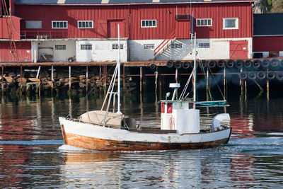 Boats moored in sea against buildings