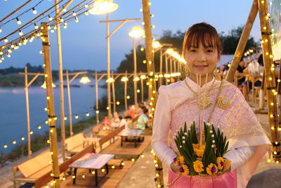 Portrait of smiling young woman standing at night