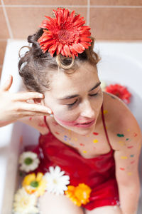 Woman with flowers in bathtub