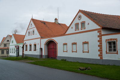 Houses by street against sky in city