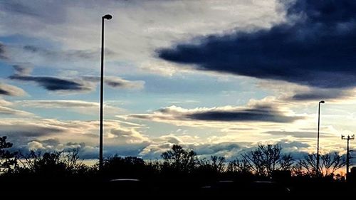 Low angle view of street light against cloudy sky