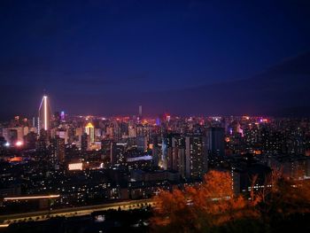 High angle view of illuminated buildings against sky at night