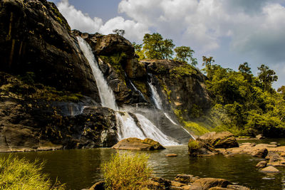 Scenic view of waterfall against sky