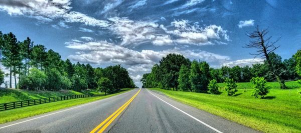 Road amidst trees against sky