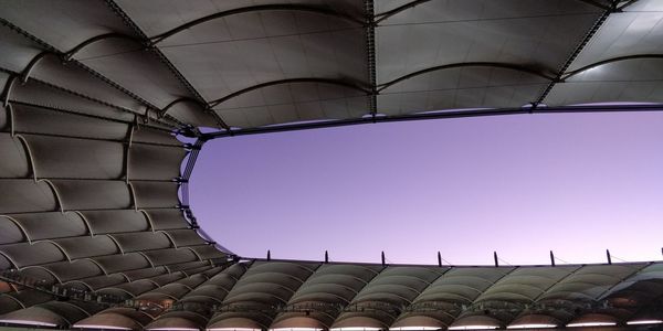 Exterior of modern stadium roof against clear sky