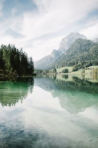 Reflection of trees and mountains on calm lake