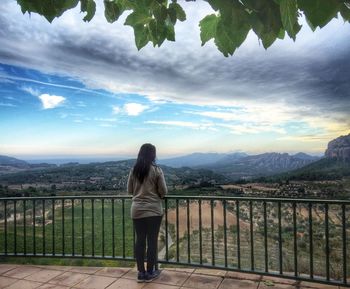 Rear view full length of woman at observation point looking towards mountains in horta de sant joan