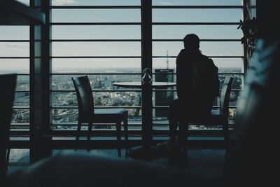 Rear view of silhouette man sitting at home