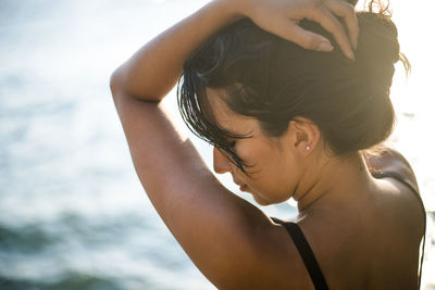 Young latina woman relaxing by the ocean at golden hour in summertime