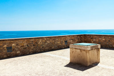 Built structure on beach against clear blue sky