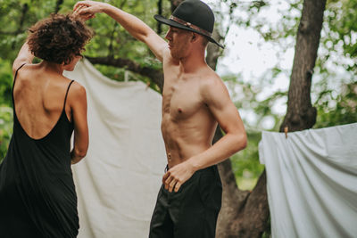 Midsection of man standing by tree