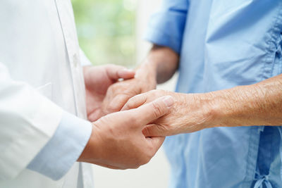 Midsection of couple holding hands