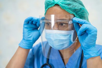 Close-up of doctor wearing face shield against white background