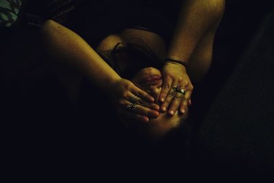 Close-up of couple hands against black background