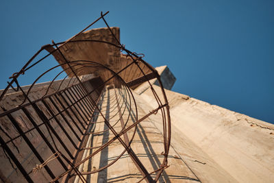 Low angle view of metallic structure against clear blue sky