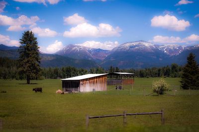 Built structure on field by mountains against sky