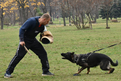 Side view of man with dog standing on grass