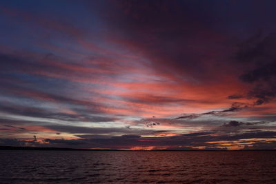 Scenic view of sea against dramatic sky during sunset