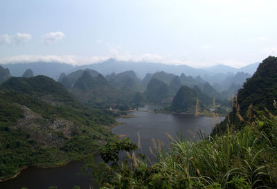 Scenic view of river and mountains against sky