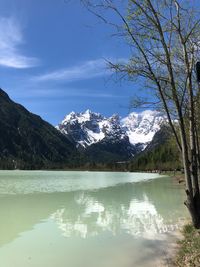 Scenic view of lake by mountains against sky