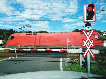 Red bus on road against sky