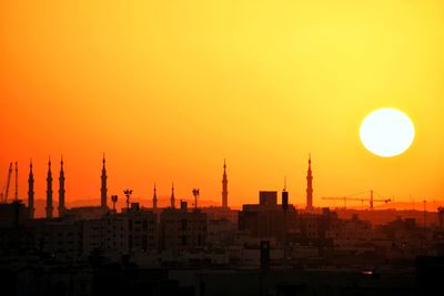 Silhouette buildings against sky during sunset