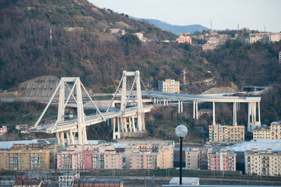 Bridge over river by buildings in city