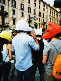 Rear view of people standing on street in city