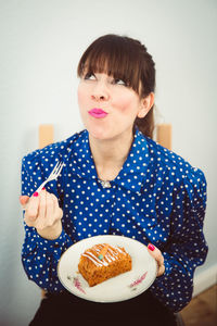 Portrait of smiling young woman holding cake