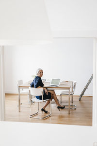 Smiling businesswoman working on laptop in office