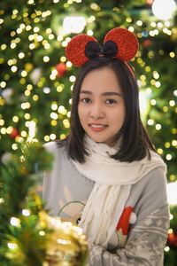 Portrait of young woman holding christmas tree