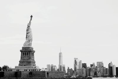 Statue of buildings in city against clear sky