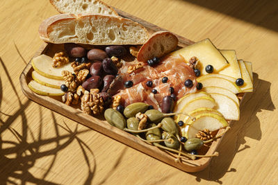 Wine plate with olives, prosciutto, nuts, bread, and cheese