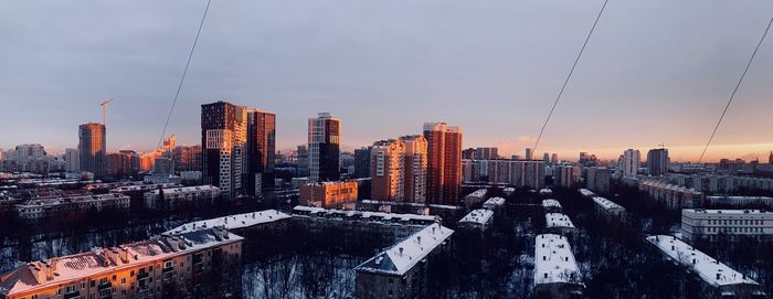 Aerial view of buildings in city during sunset