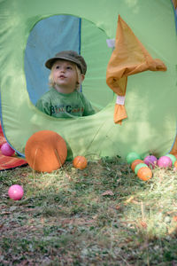 Little boy in a tent with playground in summer