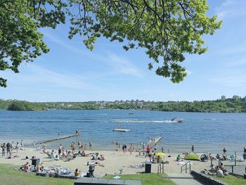 People enjoying on beach against sky