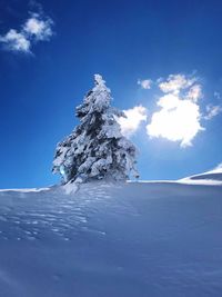 Scenic view of snowcapped mountains against blue sky