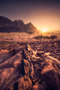 Scenic view of rocks in desert against sky during sunset