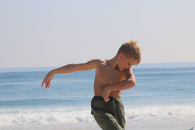 Boy dancing on beach