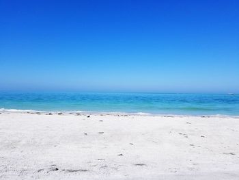 Scenic view of beach against clear blue sky