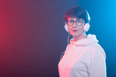 Young woman standing against blue background