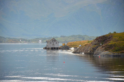 Scenic view of lake by buildings against sky