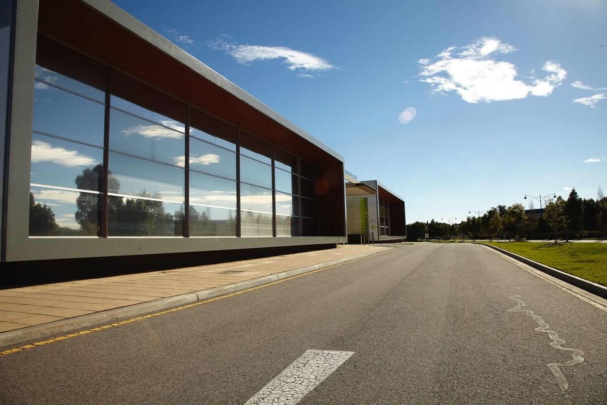 architecture, the way forward, built structure, sky, transportation, road, building exterior, diminishing perspective, road marking, empty, vanishing point, street, cloud - sky, glass - material, day, cloud, city, no people, long, outdoors