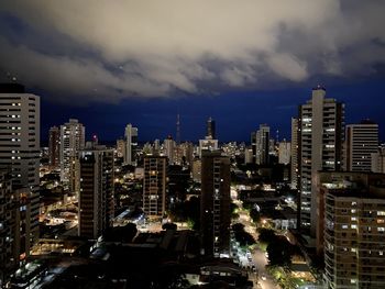 Illuminated buildings in city against sky at night